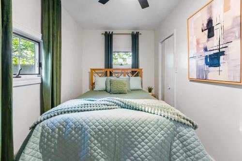 a bedroom with a bed with a green comforter at Elmhurst 3BR House with Modern Farmhouse Charm in Elmhurst