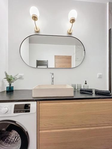une salle de bain avec un lavabo et un miroir dans l'établissement Bubbles & Lights, à Épernay