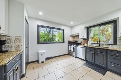 a large kitchen with white walls and blue cabinets at New Year Spot- Navy Graduation King bed pool table in Beach Park