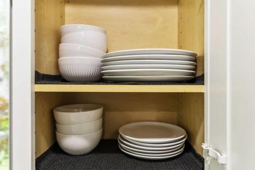 a cabinet with plates and bowls on a shelf at New Year Spot- Navy Graduation King bed pool table in Beach Park