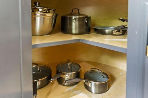 a bunch of pots and pans on a shelf in a kitchen at New Year Spot- Navy Graduation King bed pool table in Beach Park