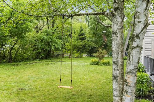 a swing hanging from a tree in a yard at New Year Spot- Navy Graduation King bed pool table in Beach Park