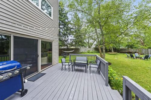 a deck with a grill and a table and chairs at New Year Spot- Navy Graduation King bed pool table in Beach Park