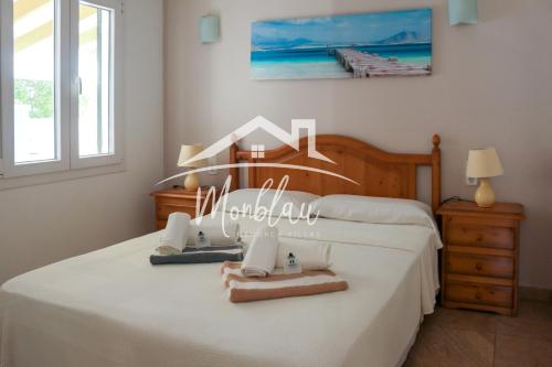 a bedroom with a bed with white sheets at ViLLA DESI in Cala en Blanes