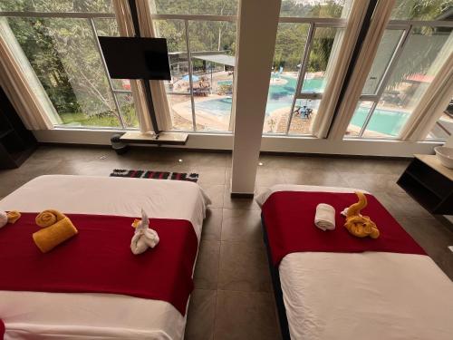 two beds in a hotel room with stuffed animals on them at Ecopark Hosteria Puyo in Puyo
