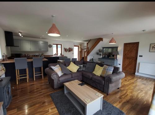 ein Wohnzimmer mit Sofa und Tisch in der Unterkunft Cottage with 360 views in Gilwern