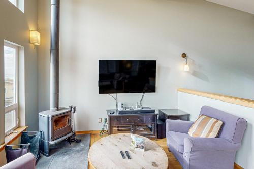 a living room with a couch and a table and a tv at Netarts Bay and Ocean Views in Netarts