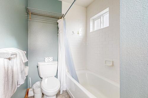 a bathroom with a toilet and a tub and a sink at Netarts Bay and Ocean Views in Netarts
