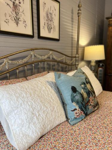 a bed with a pillow with two birds on it at Historic Hutch House in Faribault