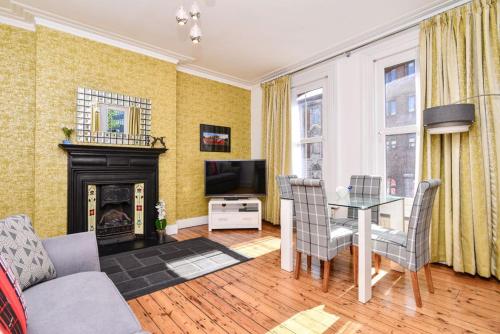 a living room with a table and a fireplace at Gorgeous First Floor apartment near Station in London