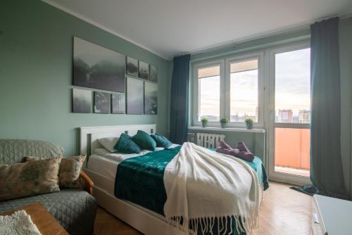een slaapkamer met een bed, een bank en ramen bij Szopy 2 in Gdańsk