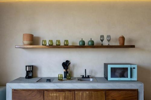 a kitchen with a counter with a microwave and a sink at Mantra Hotel Boutique in Puerto Escondido