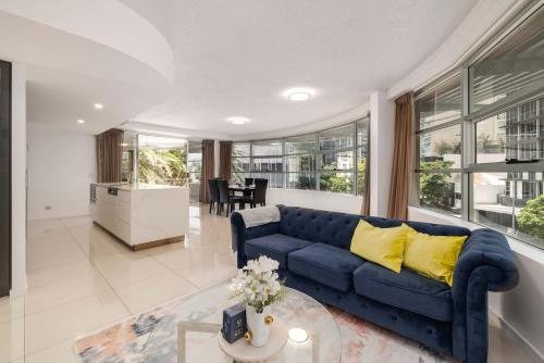 a living room with a blue couch and a table at Newly Renovated 3BR Apartment 2 Parking Spaces Pool Gym City Views Walk to Shops in Brisbane