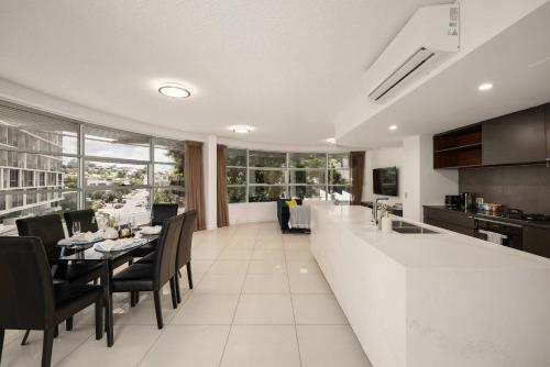 a kitchen and dining room with a table and chairs at Newly Renovated 3BR Apartment 2 Parking Spaces Pool Gym City Views Walk to Shops in Brisbane