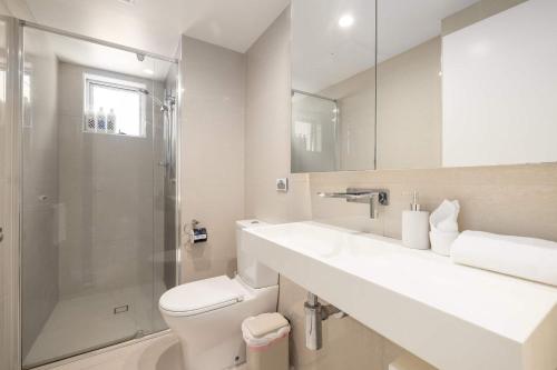 a bathroom with a toilet and a sink and a shower at Newly Renovated 3BR Apartment 2 Parking Spaces Pool Gym City Views Walk to Shops in Brisbane