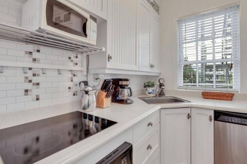 a white kitchen with a sink and a microwave at Classic Quarters at the 101 in Savannah