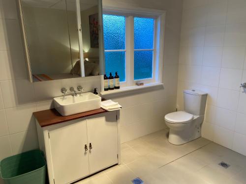 ein Badezimmer mit Waschbecken und Toilette und einem Fenster in der Unterkunft Katoomba Cosy Cottage- entire 65sqm cottage in Katoomba