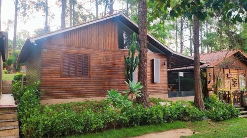 a log cabin in the woods with trees at Chalé Veraneio-Itú-SP Vista para o lago Camping Carrion in Itu