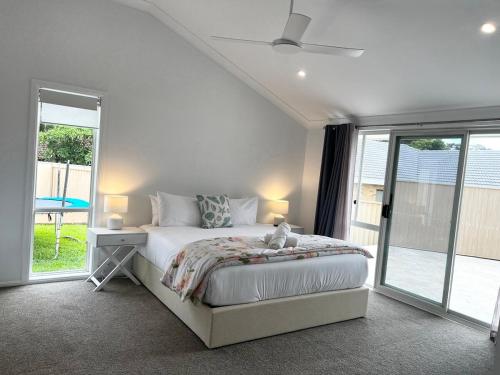 Un dormitorio blanco con una cama y una ventana. en Family retreat in Burleigh, en Gold Coast