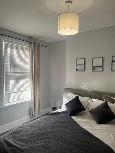 a bedroom with a large bed with a window at 2Bed Sleeps 3 - Central Near Train Station Wifi in Dartford