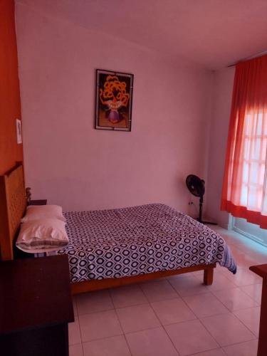 ヤウテペックにあるRest house Yautepec Bonito Privateのベッドと壁に絵が飾られた寝室