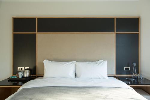 um quarto com uma cama grande e almofadas brancas em The Z Hotel Gloucester Place em Londres