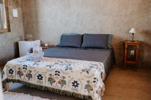 a small bedroom with a bed with a flowered blanket at Casa Mar in Prado