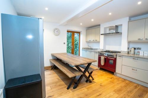a kitchen with a wooden table in the middle at 4 Bedroom Winchester Town House, central, parking in Winchester