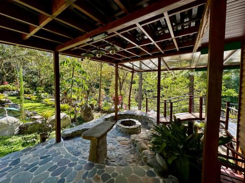 a covered patio with a bench and a table at Hotel de Montaña El Pelicano in San Isidro
