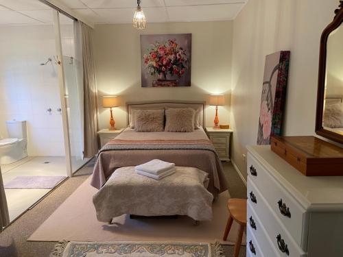 a bedroom with a large bed and a bathroom at Katoomba Cosy Cottage- entire 65sqm cottage in Katoomba