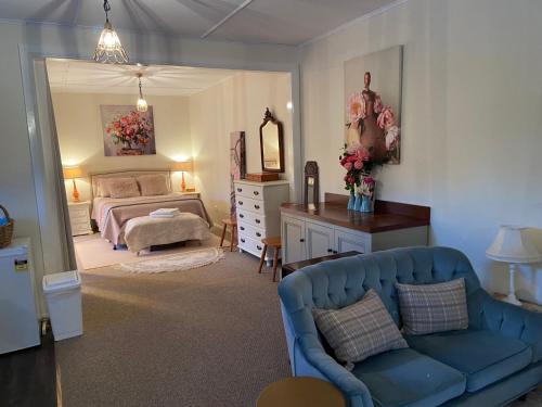 ein Wohnzimmer mit einem Bett und einer blauen Couch in der Unterkunft Katoomba Cosy Cottage- entire 65sqm cottage in Katoomba