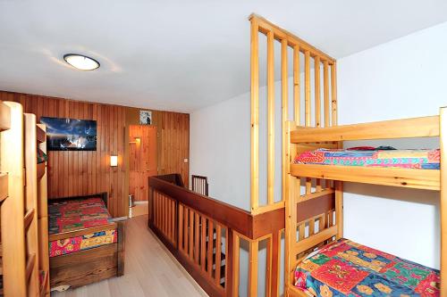 a bedroom with two bunk beds and a staircase at Appartement charmant à Les Menuires, 36 m², vue montagne. in Saint-Martin-de-Belleville