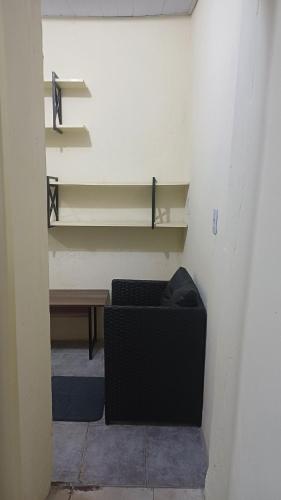 a room with a chair and a table and shelves at Residência Dazzi in Rio de Janeiro