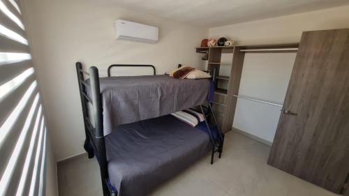 a small room with two bunk beds and a door at Casa Acapulco Playa Bonfil in Acapulco