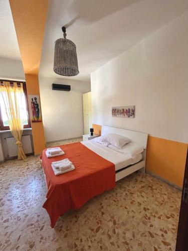 a bedroom with a large bed with a red blanket at casa al mare per famiglie 2 in Minturno