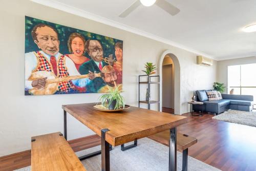 a living room with a large painting on the wall at Tranquil Arches Indooroopilly in Brisbane
