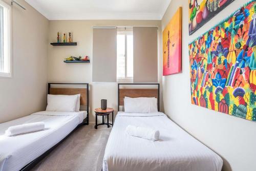 two beds in a room with a painting on the wall at Tranquil Arches Indooroopilly in Brisbane