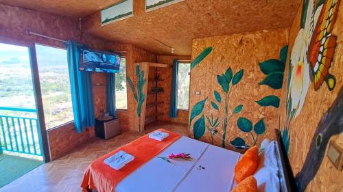 a room with a bed and a wall with a painting at Refugio Ecolodge Shapingo in Moyobamba