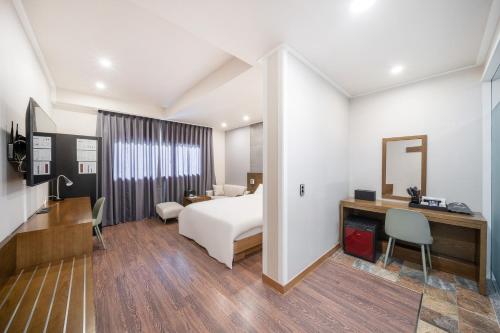 a hotel room with a bed and a desk at The 7 Business Hotel in Gumi