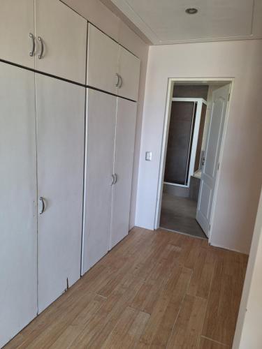 a room with white cabinets and a wooden floor at Departamento Emanuel in Comodoro Rivadavia