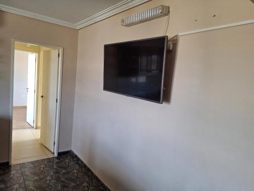 a flat screen tv on a wall in a room at Departamento Emanuel in Comodoro Rivadavia