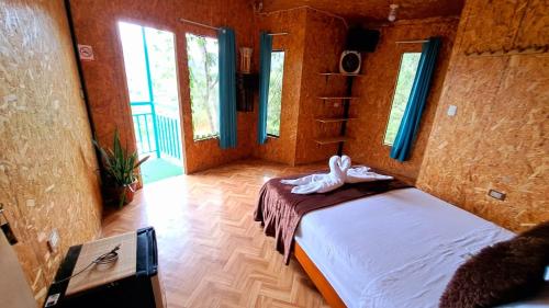 a bedroom with a bed in a room with windows at Refugio Ecolodge Shapingo in Moyobamba