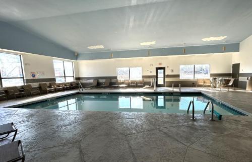 a large swimming pool in a building with chairs at Best Western Plus Pocomoke City in Pocomoke City