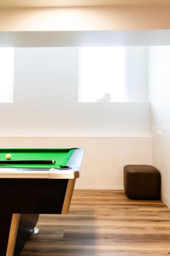 a room with a desk with a pool table at Haka House Wellington in Wellington