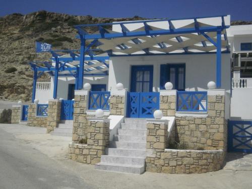 a blue and white house with blue doors and stairs at Blue and White Studios & Apartments in Lefkos Karpathou