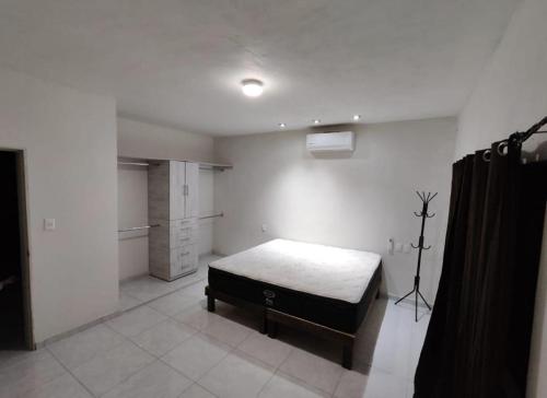Cette chambre blanche dispose d'un lit et d'une cuisine. dans l'établissement Casa constitución, à Navojoa