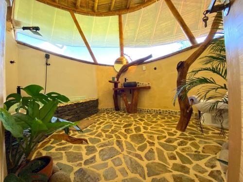 a room with a stone floor and a ceiling with a window at Aracari Ecolodge in San Rafael
