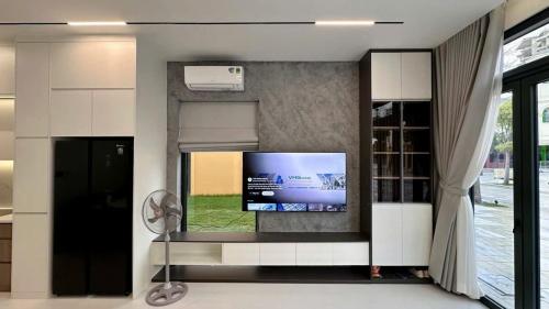 a living room with a flat screen tv on a wall at Welcome to Ho Tram Villa in Xuyên Mộc