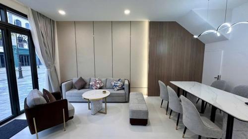 a living room with a couch and a table and chairs at Welcome to Ho Tram Villa in Xuyên Mộc