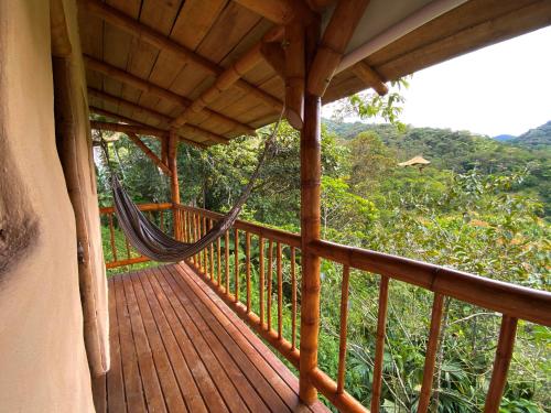 a porch with a hammock on a house at Aracari Ecolodge in San Rafael